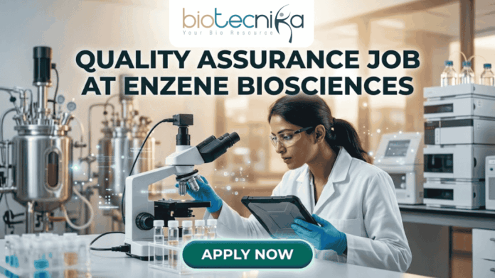 QUALITY ASSURANCE JOB AT ENZENE BIOSCIENCES A professional promotional graphic for a Quality Assurance Job at Enzene Biosciences. At the top center is the Biotecnika Professional logo, followed by the headline "QUALITY ASSURANCE JOB AT ENZENE BIOSCIENCES" in bold, dark green lettering. The image features a female scientist in a white lab coat and safety glasses, focused on a digital tablet while working in a high-tech laboratory. The setting includes a microscope, rows of clear vials on a lab bench, and large-scale industrial bioreactors in the background. A glowing teal "APPLY NOW" button is positioned prominently at the bottom center.