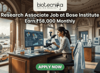 Research Associate Job at Bose Institute – Earn ₹58,000 Monthly in Top Life Science Project! Research Associate Job at Bose Institute – Earn ₹58,000 Monthly in Top Life Science Project! A professional featured image for a job posting titled "Research Associate Job at Bose Institute" with a tagline "Earn ₹58,000 Monthly." The image depicts a female scientist in a white lab coat and glasses working with a microscope and a computer monitor displaying complex molecular structures. The setting is a majestic, classical laboratory with high arched windows and ornate architecture. Visible through the window is a scenic view of Kolkata, featuring a signature yellow taxi and a river with traditional boats. The Biotecnika logo is positioned at the top, and a prominent green "APPLY NOW" button is located at the bottom center.