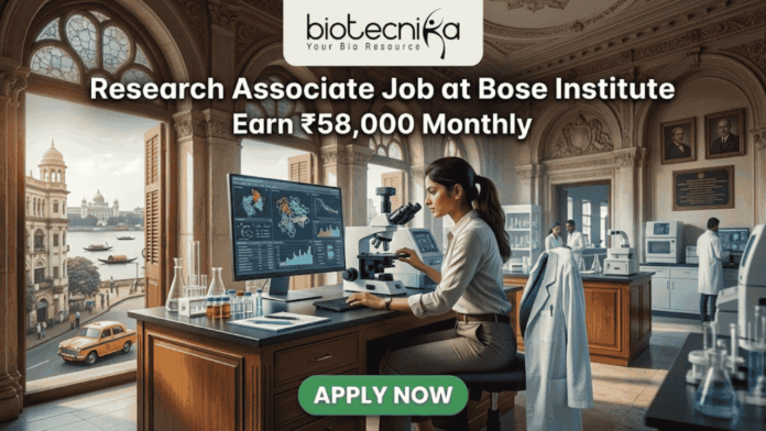Research Associate Job at Bose Institute – Earn ₹58,000 Monthly in Top Life Science Project! Research Associate Job at Bose Institute – Earn ₹58,000 Monthly in Top Life Science Project! A professional featured image for a job posting titled "Research Associate Job at Bose Institute" with a tagline "Earn ₹58,000 Monthly." The image depicts a female scientist in a white lab coat and glasses working with a microscope and a computer monitor displaying complex molecular structures. The setting is a majestic, classical laboratory with high arched windows and ornate architecture. Visible through the window is a scenic view of Kolkata, featuring a signature yellow taxi and a river with traditional boats. The Biotecnika logo is positioned at the top, and a prominent green "APPLY NOW" button is located at the bottom center.