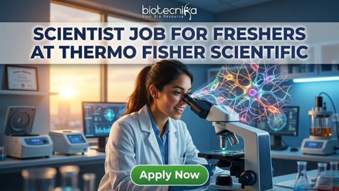 Scientist Job for Freshers at Thermo Fisher Scientific Apply Now. A recruitment advertisement image shows a female scientist in a lab coat smiling while looking into a microscope, from which a complex, colorful holographic neural network projection emerges. Overlaid text at the top reads, "SCIENTIST JOB FOR FRESHERS AT THERMO FISHER SCIENTIFIC" with the "biotecnika" logo above it. A green "Apply Now" button is at the bottom center.