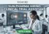 Sun Pharma Hiring Clinical Trial Assistant | Apply for Clinical Research Job! Sun Pharma Hiring Clinical Trial Assistant Apply Now. A professional and high-tech promotional image for a job opening. At the top, the Biotecnika logo is placed above the bold, capitalized headline: "SUN PHARMA HIRING CLINICAL TRIAL ASSISTANT". The central focus is a female scientist in a white lab coat and safety glasses, intently working at a desk. She is looking at a large, curved digital monitor that displays intricate clinical trial data, 3D molecular structures, and a glowing sun-like graphic representing the company theme. The laboratory setting is bright and modern, with other researchers working in the background and scientific equipment like pipettes and vials visible on the desk. At the bottom center, a vibrant green "APPLY NOW" button stands out, making the image an effective, scroll-stopping recruitment graphic.