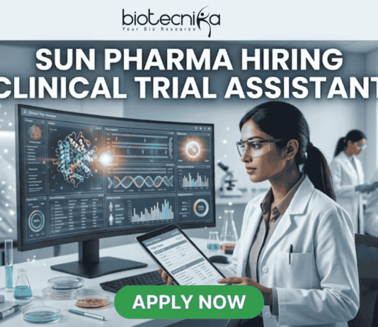 Sun Pharma Hiring Clinical Trial Assistant Apply Now. A professional and high-tech promotional image for a job opening. At the top, the Biotecnika logo is placed above the bold, capitalized headline: "SUN PHARMA HIRING CLINICAL TRIAL ASSISTANT". The central focus is a female scientist in a white lab coat and safety glasses, intently working at a desk. She is looking at a large, curved digital monitor that displays intricate clinical trial data, 3D molecular structures, and a glowing sun-like graphic representing the company theme. The laboratory setting is bright and modern, with other researchers working in the background and scientific equipment like pipettes and vials visible on the desk. At the bottom center, a vibrant green "APPLY NOW" button stands out, making the image an effective, scroll-stopping recruitment graphic.