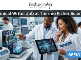 Technical Writer Job at Thermo Fisher Scientific – Life Science Career in Bangalore! A professional and realistic featured image for a job posting. Two scientists—a man and a woman—are collaborating in a modern, high-tech laboratory filled with advanced scientific equipment like centrifuges and fluidic systems. They are focused on a digital tablet displaying complex technical data and diagrams. At the top, the Biotecnika logo sits above the bold title "Technical Writer Job at Thermo Fisher Scientific." A vibrant green "APPLY NOW" button is positioned in the bottom right corner.