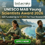 UNESCO Man and the Biosphere Programme 2026 – Get Funded Up to $5,000 for Your Research! UNESCO MAB Young Scientists Award 2026 – Get Funded Up to $5,000 for Your Research! A featured job post image for the UNESCO MAB Young Scientists Award 2026. At the top center is the Biotecnika logo. The main text reads "UNESCO MAB Young Scientists Award 2026" with a sub-headline, "Get Funded Up to $5,000 for Your Research!" The background features a realistic and vibrant tropical coastal landscape with lush green mountains and turquoise water. Two scientists—a woman and a man in khaki field gear—are shown conducting environmental research; the woman uses a handheld probe and tablet while the man inspects a sensor device mounted on a tree. Drones fly in the background, emphasizing a high-tech conservation theme. At the bottom center is a prominent green "APPLY NOW" button.