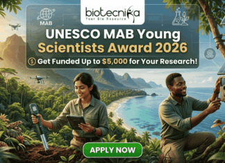 UNESCO Man and the Biosphere Programme 2026 – Get Funded Up to $5,000 for Your Research! UNESCO MAB Young Scientists Award 2026 – Get Funded Up to $5,000 for Your Research! A featured job post image for the UNESCO MAB Young Scientists Award 2026. At the top center is the Biotecnika logo. The main text reads "UNESCO MAB Young Scientists Award 2026" with a sub-headline, "Get Funded Up to $5,000 for Your Research!" The background features a realistic and vibrant tropical coastal landscape with lush green mountains and turquoise water. Two scientists—a woman and a man in khaki field gear—are shown conducting environmental research; the woman uses a handheld probe and tablet while the man inspects a sensor device mounted on a tree. Drones fly in the background, emphasizing a high-tech conservation theme. At the bottom center is a prominent green "APPLY NOW" button.