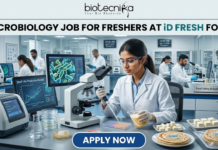 Freshers Hiring! Quality Executive Job at iD Fresh Food | Microbiology & Food Tech Eligible iD Fresh Food Hiring Quality Executive for Microbiology Job Freshers Eligible. A professional and high-quality featured image advertisement for a "Microbiology Job for Freshers at iD Fresh Food." The scene depicts a female scientist in a white lab coat and safety goggles working in a modern, high-tech Food Safety & Quality Lab. She is carefully testing food samples, such as idli/dosa batter and parottas, using a pipette and lab equipment. A computer monitor in the background shows detailed microbial cell structures. The Biotecnika logo is at the top center, the job title is displayed in bold black text, and a prominent blue "APPLY NOW" button is located at the bottom.
