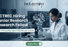 ACTREC Hiring Junior Research Fellow | Opportunity in Cancer Research ACTREC Hiring Junior Research Fellow Opportunity in Cancer Research. An advertisement for a Junior Research Fellow position at ACTREC, showing the Biotecnika logo at the top center. Text states: 'ACTREC Hiring Junior Research Fellow' and 'Get Fellowship Upto ₹35,000 per month'. A photograph on the right shows a female scientist in a lab coat, safety glasses, and blue gloves operating a multichannel pipette. Behind her, a monitor displays molecular drug discovery data. Various advanced lab instruments are in the background. At the bottom, a green 'Apply Now' button.