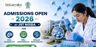 Admissions Open 2026 at JIIT Noida for MSc Microbiology, Bioinformatics & MTech Biotechnology. Featured banner for “Admissions Open 2026 at JIIT Noida” featuring the Biotecnika and JIIT logos at the top, a scientist performing drug research in a modern laboratory, molecular and pharmaceutical-themed graphics, a university campus backdrop, program highlights for MSc Microbiology, MSc Bioinformatics, and MTech Biotechnology, and a bold “Apply Now” button at the bottom.