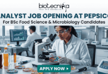 Analyst Job Opening at PepsiCo for BSc Food Science & Microbiology Candidates Analyst Job at PepsiCo BSc Food Science & Microbiology. A promotional banner from Biotecnika advertising an "ANALYST JOB OPENING AT PEPSICO for BSc Food Science & Microbiology Candidates". The visual features a female researcher in a lab coat and safety glasses using a compound microscope to examine colorful samples in a Petri dish. Laboratory equipment, test bottles with various food product liquids, and a male colleague working at a computer station are in the background. The Biotecnika logo is at the top, and a teal "APPLY NOW" button is at the bottom.