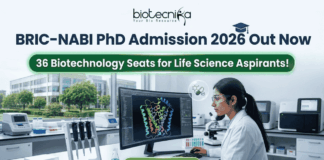 BRIC-NABI PhD Admission 2026 Out Now – 36 Biotechnology Seats! BRIC-NABI PhD Admission 2026 Out Now – 36 Biotechnology Seats for Life Science Aspirants!. A high-resolution corporate featured image for BRIC-NABI PhD Admission 2026. The top center features the Biotecnika logo above the bold text: "BRIC-NABI PhD Admission 2026 Out Now." Below this, a glowing green banner highlights "36 Biotechnology Seats for Life Science Aspirants!" The background shows a modern, bright laboratory setting where a female scientist is focused on a large curved monitor displaying a colorful 3D protein molecular structure. Lab equipment, including pipettes and a microscope, is visible on the clean white workstation. At the bottom center, there is a prominent green "Apply Now" button with a right-arrow icon.