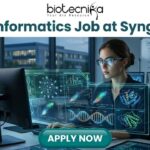 Bioinformatics Job at Syngene Apply For Principal Scientist Role Today! A promotional banner for biotecnika advertising a "Bioinformatics Job at Syngene." The biotecnika logo is at the top center. The main image shows a woman with smart glasses working intensely at a high-tech computational workstation. A holographic overlay features detailed biological data visualizations, including DNA double-helices, molecular models, and complex data graphs. In the background, a whiteboard has the text "Genome Assembly Pipeline," and an urban night scene is visible through the window. At the bottom, a prominent green "APPLY NOW" button is centered.