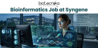 Bioinformatics Job at Syngene | Apply For Principal Scientist Role Today! Bioinformatics Job at Syngene Apply For Principal Scientist Role Today! A promotional banner for biotecnika advertising a "Bioinformatics Job at Syngene." The biotecnika logo is at the top center. The main image shows a woman with smart glasses working intensely at a high-tech computational workstation. A holographic overlay features detailed biological data visualizations, including DNA double-helices, molecular models, and complex data graphs. In the background, a whiteboard has the text "Genome Assembly Pipeline," and an urban night scene is visible through the window. At the bottom, a prominent green "APPLY NOW" button is centered.