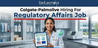 Colgate-Palmolive Hiring For Regulatory Affairs Job | BSc Life Science Job Colgate-Palmolive Hiring For Regulatory Affairs Job BSc Life Science Job. An image advertising a Regulatory Affairs job opening at Colgate-Palmolive, presented by Biotecnika. A smiling female regulatory specialist in a lab coat holds a tablet displaying a certified compliance status with US and EU flags and a green checkmark. A blue 'APPLY NOW' button is at the bottom.