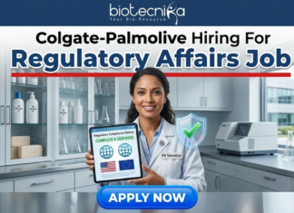 Colgate-Palmolive Hiring For Regulatory Affairs Job | BSc Life Science Job Colgate-Palmolive Hiring For Regulatory Affairs Job BSc Life Science Job. An image advertising a Regulatory Affairs job opening at Colgate-Palmolive, presented by Biotecnika. A smiling female regulatory specialist in a lab coat holds a tablet displaying a certified compliance status with US and EU flags and a green checkmark. A blue 'APPLY NOW' button is at the bottom.