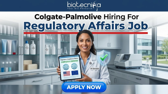 Colgate-Palmolive Hiring For Regulatory Affairs Job BSc Life Science Job Colgate-Palmolive Hiring For Regulatory Affairs Job BSc Life Science Job. An image advertising a Regulatory Affairs job opening at Colgate-Palmolive, presented by Biotecnika. A smiling female regulatory specialist in a lab coat holds a tablet displaying a certified compliance status with US and EU flags and a green checkmark. A blue 'APPLY NOW' button is at the bottom.
