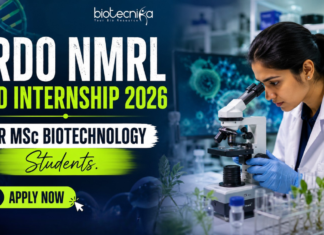 DRDO NMRL Paid Internship 2026 For M.Sc Biotechnology Students DRDO NMRL Paid Internship 2026 For MSc Biotechnology Students. Featured image showing a realistic biotechnology laboratory scene with a young female scientist using a microscope in a modern research lab. Bold text highlights “DRDO NMRL Paid Internship 2026 For MSc Biotechnology Students” with a bright neon-green and blue theme. The Biotecnika logo appears at the top center, while a large “Apply Now” button is placed prominently at the bottom. The design is vibrant, professional, and attention-grabbing, featuring biotech visuals such as DNA strands, lab equipment, and research elements to appeal to MSc Biotechnology students.