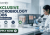 Exclusive Microbiology Jobs at Minimalist | Apply For Quality Assurance Executive Role Exclusive Microbiology Jobs at Minimalist Apply For Quality Assurance Executive Role. A professional corporate recruitment banner for "EXCLUSIVE MICROBIOLOGY JOBS @ Minimalist" featuring the Biotecnika logo. The image showcases a focused female scientist in a white lab coat and blue gloves working in a high-tech laboratory. The theme is centered on skincare science, with laboratory monitors displaying "Skin Microbiome Analysis" and "Probiotic Effectiveness." Shelves in the background hold various skincare bottles and jars. Hexagonal graphics highlight scientific visualizations of skin cells and probiotic serums. Four circular icons at the bottom represent research, aquatic sciences, innovation, and skincare product formulation. A prominent green "APPLY NOW" button is positioned at the bottom left.