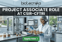 Urgent Hiring: Project Associate Role at CSIR-CFTRI | MSc Food Science Job 2026! Project Associate Role at CSIR-CFTRI. A realistic, wide featured image of a dynamic food technology lab at a prestigious research campus. A young female scientist meticulously works on advanced machinery and nutrient-dense food prototypes. Bold white text at the top states "PROJECT ASSOCIATE ROLE" followed by "AT CSIR-CFTRI". The full biotecnika logo is also at the top center, and a green button at the bottom reads "Apply now".