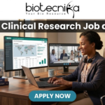 Hybrid Clinical Research Job at ICON | Life Science Graduates Must Apply! A job advertisement banner from Biotecnika for a Clinical Research position at ICON. The top center features the "biotecnika" logo with the tagline "Your Bio Resource". Below the logo, a prominent dark grey bar contains the large, bold white text headline: "Hybrid Clinical Research Job at ICON". The main visual is a detailed, realistic illustrative scene of a professional woman in a blazer and headphones seated at a desk with an office cityscape in the background. She is looking at three computer monitors: one showing a "Global Trial Management" data dashboard, another showing a live video conference with a team (labeled "Team Check-in - Remote Site"), and the third is a laptop. Objects on the desk include a coffee mug that reads "COFFEE & CLINICAL DATA", a stack of "Good Clinical Practice Guide" books, and vials. At the bottom center, a pulsing teal-colored rounded rectangular button with white text reads "APPLY NOW".