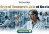 Latest Clinical Research Job for Life Science & Biomedical Graduates at Baxter | Apply Now Latest Clinical Research Job at Baxter | Apply Now. A featured job advertisement banner for biotecnika, titled "Clinical Research Job at Baxter," set in a modern, futuristic laboratory. The visual focuses on a diverse female scientist, of South Asian or Indian descent, with safety glasses and a lab coat, who is interacting with and gesturing towards a floating, transparent holographic screen. The screen displays complex 3D molecular models of a protein and a drug, along with labels like 'Protein Drug Docking' and 'Data Docking'. In the blurred background, other researchers work with equipment and computer monitors in a well-equipped facility. At the top center is the "biotecnika Your Bio Resource" logo. At the bottom center, a prominent green button contains the text 'Apply Now' with a white arrow icon.