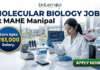 ₹61,000 Salary Molecular Biology Job at MAHE Manipal | Apply. A professional recruitment banner from Biotecnika for a "Molecular Biology Job at MAHE Manipal." The image features a female scientist in a lab coat and safety glasses, meticulously using a multichannel pipette at a well-equipped laboratory bench. The banner prominently highlights the text "Earn Upto ₹61,000 Salary." and includes other text elements like "biotecnika" and "MOLECULAR BIOLOGY JOB at MAHE Manipal." In the background, other lab instruments, computer monitors displaying biological data, and a modern university campus through the windows are visible. Icons for a pipette, a DNA helix, and a multiwell plate, along with hexagonal frames showing biological research images, represent the drug research theme. A large, green, glowing "APPLY NOW" button is in the bottom right corner.