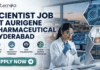 Scientist Job in Hyderabad for MSc Graduates | Aurigene Pharmaceutical Hiring Now Scientist Job for MSc Graduates at Aurigene Pharmaceutical. A professional corporate recruitment banner for a "SCIENTIST JOB AT AURIGENE PHARMACEUTICAL HYDERABAD" by Biotecnika. The image features a focused female scientist of Indian heritage in a lab coat and safety glasses, working with a multichannel pipette in a state-of-the-art pharmaceutical laboratory. The background shows a modern research facility with large windows overlooking a city skyline at dusk. Hexagonal frames to the right showcase a DNA helix, chemical glassware, and data analytics. Below the main headline, four icons highlight key aspects: Advanced Drug R&D, High-Throughput Screening, Team Collaboration, and Career Growth Opportunities. A prominent teal "APPLY NOW" button is positioned at the bottom left.