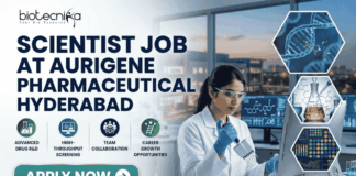 Scientist Job in Hyderabad for MSc Graduates | Aurigene Pharmaceutical Hiring Now Scientist Job for MSc Graduates at Aurigene Pharmaceutical. A professional corporate recruitment banner for a "SCIENTIST JOB AT AURIGENE PHARMACEUTICAL HYDERABAD" by Biotecnika. The image features a focused female scientist of Indian heritage in a lab coat and safety glasses, working with a multichannel pipette in a state-of-the-art pharmaceutical laboratory. The background shows a modern research facility with large windows overlooking a city skyline at dusk. Hexagonal frames to the right showcase a DNA helix, chemical glassware, and data analytics. Below the main headline, four icons highlight key aspects: Advanced Drug R&D, High-Throughput Screening, Team Collaboration, and Career Growth Opportunities. A prominent teal "APPLY NOW" button is positioned at the bottom left.