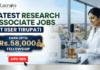 Latest Research Associate Jobs at IISER Tirupati | Earn Upto Rs.58,000 Fellowship Latest Research Associate Jobs at IISER Tirupati | Earn Upto Rs.58,000 Fellowship. A professional recruitment banner for "Latest Research Associate Jobs at IISER Tirupati," featuring the Biotecnika logo at the top left. On the right, a female scientist in a white lab coat and gloves is shown working with a laboratory bioreactor in a bright, modern lab setting. The background through a large window offers a realistic view of the IISER Tirupati campus. The left side of the image features the bold headline "LATEST RESEARCH ASSOCIATE JOBS AT IISER TIRUPATI." Below this, a prominent gold-framed blue box highlights the fellowship: "EARN UPTO Rs. 58,000 FELLOWSHIP" accompanied by an icon of a money bag. Three circular icons highlight key benefits: Conduct Advanced Bio-Research, Collaboration & Mentorship, and Career Growth Path. A large green "Apply Now" button with a white arrow and the website "biotecnika.org" are positioned at the bottom.