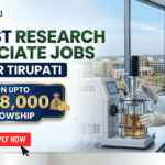 Latest Research Associate Jobs at IISER Tirupati | Earn Upto Rs.58,000 Fellowship. A professional recruitment banner for "Latest Research Associate Jobs at IISER Tirupati," featuring the Biotecnika logo at the top left. On the right, a female scientist in a white lab coat and gloves is shown working with a laboratory bioreactor in a bright, modern lab setting. The background through a large window offers a realistic view of the IISER Tirupati campus. The left side of the image features the bold headline "LATEST RESEARCH ASSOCIATE JOBS AT IISER TIRUPATI." Below this, a prominent gold-framed blue box highlights the fellowship: "EARN UPTO Rs. 58,000 FELLOWSHIP" accompanied by an icon of a money bag. Three circular icons highlight key benefits: Conduct Advanced Bio-Research, Collaboration & Mentorship, and Career Growth Path. A large green "Apply Now" button with a white arrow and the website "biotecnika.org" are positioned at the bottom.