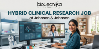 Hybrid Clinical Research Job at Johnson & Johnson Across India | Apply Now Hybrid Clinical Research Job at Johnson & Johnson Apply Now. A marketing banner promoting a "HYBRID CLINICAL RESEARCH JOB at Johnson & Johnson", featuring the Biotecnika logo. The central image shows a woman working at a desk, split between a laboratory environment (pipettes, vials) on the left and a home office (bookshelves, cat) on the right. She has dual monitors: one displaying research data, another showing a video conference call. Text on her desk nameplate says, "NAME - CLINICAL RESEARCHER at J&J". A large call-to-action button at the bottom reads "APPLY NOW".