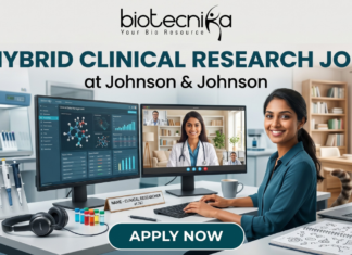 Hybrid Clinical Research Job at Johnson & Johnson Across India | Apply Now Hybrid Clinical Research Job at Johnson & Johnson Apply Now. A marketing banner promoting a "HYBRID CLINICAL RESEARCH JOB at Johnson & Johnson", featuring the Biotecnika logo. The central image shows a woman working at a desk, split between a laboratory environment (pipettes, vials) on the left and a home office (bookshelves, cat) on the right. She has dual monitors: one displaying research data, another showing a video conference call. Text on her desk nameplate says, "NAME - CLINICAL RESEARCHER at J&J". A large call-to-action button at the bottom reads "APPLY NOW".