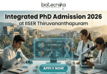 Integrated PhD Admission 2026 at IISER Thiruvananthapuram | Applications Invited Integrated PhD Admission 2026 at IISER Thiruvananthapuram. An inspiring featured image for Integrated PhD admission, featuring three students in lab coats collaborating in a modern IISER Thiruvananthapuram laboratory during golden hour. Large text at the top reads: "Integrated PhD Admission 2026 at IISER Thiruvananthapuram", with the Biotecnika logo. Below, students are pointing at a transparent screen with DNA structures and using a microscope, with a witty "Caffeine & CRISPR" mug. A large teal "APPLY NOW" button is at the bottom center.