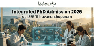 Integrated PhD Admission 2026 at IISER Thiruvananthapuram. An inspiring featured image for Integrated PhD admission, featuring three students in lab coats collaborating in a modern IISER Thiruvananthapuram laboratory during golden hour. Large text at the top reads: "Integrated PhD Admission 2026 at IISER Thiruvananthapuram", with the Biotecnika logo. Below, students are pointing at a transparent screen with DNA structures and using a microscope, with a witty "Caffeine & CRISPR" mug. A large teal "APPLY NOW" button is at the bottom center.