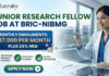 Junior Research Fellow Job at BRIC-NIBMG With ₹37,000 Salary, Apply Before 8 June! Junior Research Fellow Job at BRIC-NIBMG Apply Now. A promotional banner from Biotecnika for a Junior Research Fellow Job at BRIC-NIBMG. A central highlighted box states, "MONTHLY EMOLUMENTS: ₹37,000 PER MONTH PLUS 24% HRA" (indicated by small house icons). The banner features three benefits icons in green: "Advanced Research Facilities" with a microscope, "Genomics & Health" with a DNA helix, and "Career Mentorship" with a rising graph. A female scientist in a lab coat and safety glasses smiles while interacting with a futuristic holographic display showing intricate molecular structures and cellular data graphs. A prominent green button at the bottom says "APPLY NOW". The Biotecnika "Your Bio Resource" logo is prominent at the top left, and the website "www.biotecnika.org" is at the bottom right.