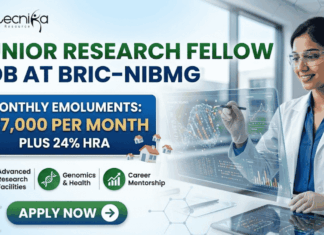 Junior Research Fellow Job at BRIC-NIBMG With ₹37,000 Salary, Apply Before 8 June! Junior Research Fellow Job at BRIC-NIBMG Apply Now. A promotional banner from Biotecnika for a Junior Research Fellow Job at BRIC-NIBMG. A central highlighted box states, "MONTHLY EMOLUMENTS: ₹37,000 PER MONTH PLUS 24% HRA" (indicated by small house icons). The banner features three benefits icons in green: "Advanced Research Facilities" with a microscope, "Genomics & Health" with a DNA helix, and "Career Mentorship" with a rising graph. A female scientist in a lab coat and safety glasses smiles while interacting with a futuristic holographic display showing intricate molecular structures and cellular data graphs. A prominent green button at the bottom says "APPLY NOW". The Biotecnika "Your Bio Resource" logo is prominent at the top left, and the website "www.biotecnika.org" is at the bottom right.