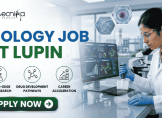 Latest Biology Job At Lupin | BSc Candidates Apply Before It’s Gone! Latest Biology Job At Lupin BSc Candidates Apply Before It's Gone! A detailed, professional recruitment banner for a "BIOLOGY JOB AT LUPIN" by biotecnika Your Bio Resource. The banner features a focused female Indian scientist in a lab coat and safety glasses, using a multichannel pipette to fill a microplate in a modern laboratory. Overlaid on the background, which includes a campus view and scientific monitors with bio-prospecting data and molecular models, are hexagonal panels displaying a DNA helix, a cell structure, and a plant sample. Three key career benefits are listed with icons in green circles: "CUTTING-EDGE DRUG RESEARCH", "DRUG DEVELOPMENT PATHWAYS", and "CAREER ACCELERATION". A prominent green "APPLY NOW" button with a white right arrow is at the bottom center. The company logo is at the top left, and the job title text is prominent on the left.