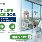Latest Life Science Job at South Asian University in Delhi Apply Now. A professional recruitment banner for the "Latest Life Science Job at South Asian University in Delhi," featuring the Biotecnika logo at the top left. On the right, a female scientist in a white lab coat and safety glasses is shown using a multichannel pipette on a microplate in a modern laboratory setting. The background through a large window offers a clear, realistic view of the India Gate in Delhi, symbolizing the job location. The left side features the bold headline "LATEST LIFE SCIENCE JOB AT SOUTH ASIAN UNIVERSITY IN DELHI" and three green circular icons representing: Advanced Bio-sciences, Global Impact & Reach, and Career Growth Path. A prominent green "apply now" button with a white arrow and the website "biotecnika.org" are located at the bottom.