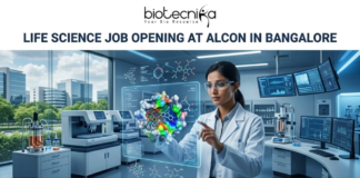Life Science Job Opening at Alcon in Bangalore. A corporate job advertisement banner for a Life Science Job Opening at Alcon in Bangalore. The image features a female scientist of South Asian descent in a high-tech laboratory, interacting with a glowing holographic 3D protein-drug molecular model. The background shows advanced lab equipment, data monitors, and a view of modern Bangalore buildings through a large window. The Biotecnika logo is at the top center, the headline is in bold dark text, and a green 'Apply Now' button is located at the bottom.