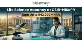 Life Science Vacancy at CSIR-NIScPR Earn Up to ₹42,000 + HRA. A promotional job advertisement banner for a "Life Science Vacancy at CSIR-NIScPR." The central image features a female researcher in a lab coat and gloves at a sophisticated laboratory desk. She is using a micropipette with a futuristic, transparent data display. Foreground objects include a microscope, a multi-well plate, stacks of scientific journals, and a DNA helix model. Behind her are large windows showing a grand, classical-style campus building under a sunny sky, representing the institute. At the top center, the Biotecnika "Your Bio Resource" logo is visible. The text reads: "Life Science Vacancy at CSIR-NIScPR", with a prominent gold banner below highlighting: "Earn Up to ₹42,000 + HRA". A large, pulsing teal button at the bottom center says "APPLY NOW."
