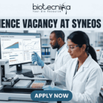 Life Science Vacancy at Syneos Health BSc Candidates Apply Now. A complete job advertisement featured image banner. At the very top center, it features the full Biotecnika logo and tagline ("biotecnika", abstract human-leaf figure, "Your Bio Resource"). Directly below, a large text headline reads: "LIFE SCIENCE VACANCY AT SYNEOS HEALTH". The main scene is a photograph of a modern, well-equipped laboratory with two focused researchers. A female researcher in the foreground is actively pipetting over microtiter plates. Behind her, her male colleague works at a large computer station. The monitor screen is clearly legible and displays complex "PHASE III TRIAL TRACKING" data, graphs, and clinical recruitment charts. Advanced lab equipment like an automated liquid handling system and color-coded samples are on the bench, alongside a lab notebook with molecular doodles. At the bottom center, a prominent deep teal-blue button with bold white text displays "APPLY NOW".