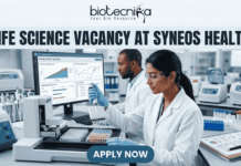 Life Science Vacancy at Syneos Health | BSc Candidates Apply Now Life Science Vacancy at Syneos Health BSc Candidates Apply Now. A complete job advertisement featured image banner. At the very top center, it features the full Biotecnika logo and tagline ("biotecnika", abstract human-leaf figure, "Your Bio Resource"). Directly below, a large text headline reads: "LIFE SCIENCE VACANCY AT SYNEOS HEALTH". The main scene is a photograph of a modern, well-equipped laboratory with two focused researchers. A female researcher in the foreground is actively pipetting over microtiter plates. Behind her, her male colleague works at a large computer station. The monitor screen is clearly legible and displays complex "PHASE III TRIAL TRACKING" data, graphs, and clinical recruitment charts. Advanced lab equipment like an automated liquid handling system and color-coded samples are on the bench, alongside a lab notebook with molecular doodles. At the bottom center, a prominent deep teal-blue button with bold white text displays "APPLY NOW".