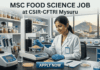 MSc Food Science Job at CSIR-CFTRI Mysuru | Apply Before Deadline! MSc Food Science Job at CSIR-CFTRI Apply Online. A realistic photograph with text overlay at the top: 'MSC FOOD SCIENCE JOB at CSIR-CFTRI Mysuru.' A smiling female food scientist in a white lab coat and gloves is depicted operating a grain analysis machine in a laboratory. The well-stocked shelves behind her hold numerous jars of cereal samples and lab equipment. In the background, a large window frames the view of the city of Mysuru, including a distinctive temple gopuram on Chamundi Hill under a warm sky. At the bottom, a prominent blue button states 'APPLY NOW'."