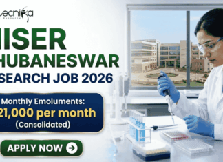 NISER Bhubaneswar Research Job 2026 – Life Sciences Graduates Can Apply NISER Bhubaneswar Research Job 2026 – Life Sciences Graduates Can Apply. A professional recruitment banner for "NISER Bhubaneswar Research Job 2026," featuring the Biotecnika logo at the top left. On the right, a female scientist in a white lab coat and blue gloves is precisely using a pipette on a multi-well plate in a bright, modern laboratory. The left side displays the bold headline "NISER BHUBANESWAR RESEARCH JOB 2026." Below the title, a prominent gold-framed blue box highlights the salary: "Monthly Emoluments: ₹21,000 per month (Consolidated)." The background through the lab window shows a realistic view of the NISER Bhubaneswar campus. A large green "Apply Now" button with a white arrow is positioned at the bottom left.