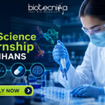 Online Life Science Internship at NIMHANS | Opportunity for UG & PG Students Online Life Science Internship at NIMHANS Opportunity for UG & PG Students “Featured banner for an Online Life Science Internship at NIMHANS, showing a female scientist conducting drug research in a modern biotech laboratory with test tubes, microscope, and digital brain scan displays. The Biotecnika logo is placed at the top, with a glowing ‘Apply Now’ button at the bottom and futuristic blue scientific graphics in the background.”