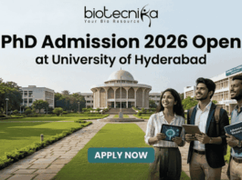 PhD Admission 2026 Open at University of Hyderabad. An advertisement for PhD Admission 2026 at the University of Hyderabad. The image features a photo of the university campus with three smiling people walking on a pathway, one holding a tablet showing a molecular diagram and another holding a book titled 'Advanced Research'. The biotecnika logo is at the top center. The main headline is 'PhD Admission 2026 Open at University of Hyderabad'. There is a green 'APPLY NOW' button with subtext providing a website and application deadline: 'Visit www.biotecnika.org for application details. Application Deadline: October 2025'.