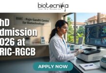 PhD Admission 2026 at BRIC-RGCB | Unlock Your Life Science Career Dream! PhD Admission 2026 at BRIC-RGCB Unlock Your Life Science Career Dream! Promotional banner for Biotecnika, "Your Bio Resource," advertising PhD Admission 2026 at BRIC-RGCB (Rajiv Gandhi Centre for Biotechnology). The central image is of a female scientist in safety glasses and a lab coat working with advanced lab equipment and a large computer monitor displaying DNA and protein visualizations. In the background, a sign on a glass partition reads "BRIC - Rajiv Gandhi Centre for Biotechnology," and a modern research campus is visible through windows. At the bottom, a prominent green button with white text says "APPLY NOW."