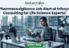 Pharmacovigilance Job Alert at Infosys Consulting for Life Science Experts! A job advertisement graphic with text at the top that reads: "biotecnika" and "Your Bio Resource" with a stylized icon, followed by the headline, "Pharmacovigilance Job Alert at Infosys Consulting for Life Science Experts!". The central image shows a woman of South Asian descent wearing a headset, seated at a desk with a laptop in a modern office setting. She is looking at and reaching toward a futuristic, transparent data display interface with molecular structures, a world map, data charts, and labels like "Safety Reports," "Product Reports," and a "Safety Map" legend indicating colored zones for alert, warning, and safety. Other employees are working at desks in the background of a glass-walled high-rise office. At the bottom center, there is a large green button with white text that reads "APPLY NOW", and a hand cursor is clicking it.