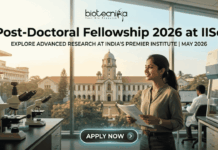Post-Doctoral Fellowship 2026 at IISc | Earn ₹80,000/Month + ₹2 Lakh Grant Post-Doctoral Fellowship At IISc Bengaluru Earn ₹2 Lakh Grant. An attractive and realistic featured image for a job page from biotecnika. At the top, the biotecnika logo is centered. Large, bold centered text below reads, "Post-Doctoral Fellowship 2026 at IISc," with a smaller sub-headline that says, "EXPLORE ADVANCED RESEARCH AT INDIA'S PREMIER INSTITUTE | MAY 2026." The image features a female Indian researcher smiling in a modern laboratory, holding documents. Various lab equipment like microscopes and other scientists in the background are visible. Through the large windows, a recognizable, grand academic building and trees are visible, implying the IISc campus under a warm, golden light. At the bottom center, a rounded button reads "APPLY NOW >." The image is relatable, attention-grabbing, and unique.