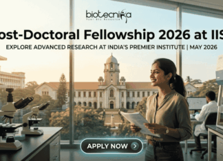 Post-Doctoral Fellowship 2026 at IISc | Earn ₹80,000/Month + ₹2 Lakh Grant Post-Doctoral Fellowship At IISc Bengaluru Earn ₹2 Lakh Grant. An attractive and realistic featured image for a job page from biotecnika. At the top, the biotecnika logo is centered. Large, bold centered text below reads, "Post-Doctoral Fellowship 2026 at IISc," with a smaller sub-headline that says, "EXPLORE ADVANCED RESEARCH AT INDIA'S PREMIER INSTITUTE | MAY 2026." The image features a female Indian researcher smiling in a modern laboratory, holding documents. Various lab equipment like microscopes and other scientists in the background are visible. Through the large windows, a recognizable, grand academic building and trees are visible, implying the IISc campus under a warm, golden light. At the bottom center, a rounded button reads "APPLY NOW >." The image is relatable, attention-grabbing, and unique.