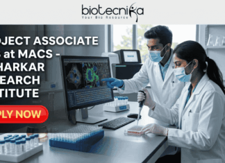 Project Associate Job at MACS - Agharkar Research Institute. A detailed job advertisement graphic for a Project Associate position at MACS - Agharkar Research Institute in Pune, India, from Biotecnika, 'Your Bio Resource'. The left side displays bold text. On the right, a photograph shows two masked scientists in a modern laboratory, one pointing to a screen with colorful cellular images and the other using a pipette. A teal button at the bottom reads 'Apply Now'.